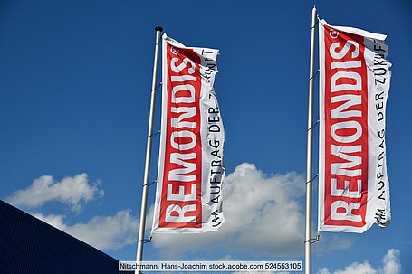 Zwei rot-weiße Remonids-Fahnen vor leicht bewölktem Himmel
