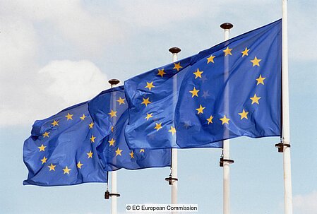 Reihe von vier Fahnenmasten mit der EU-Flagge