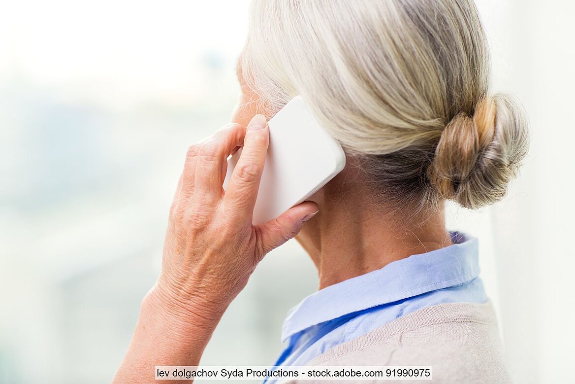 Rückansicht älterer Frau mit Telefon am Ohr