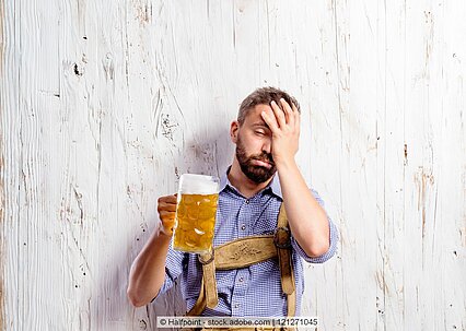 Ein Mann in Tracht hält ein Bier in einem Maßkrug.