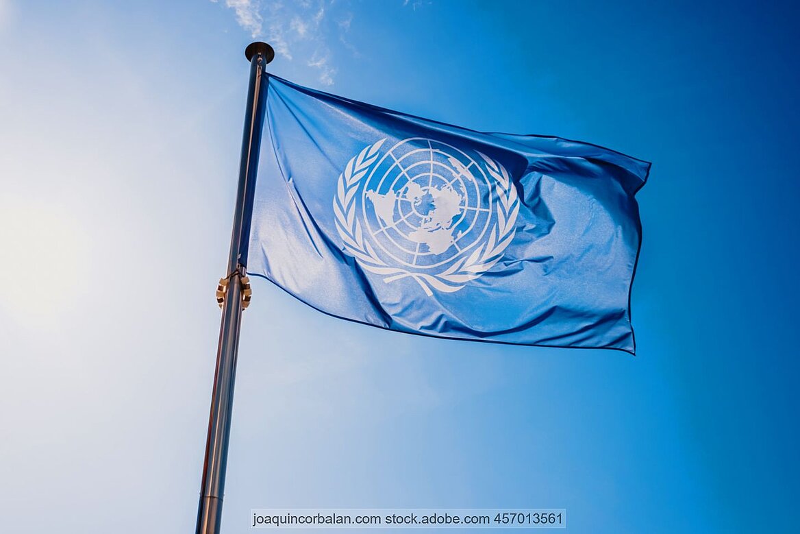 Flagge der Vereinten Nationen vor blauem Himmel