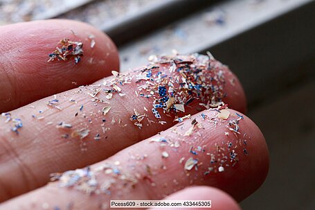 Großaufnahme von Mikroplastik-Partikeln auf Fingern