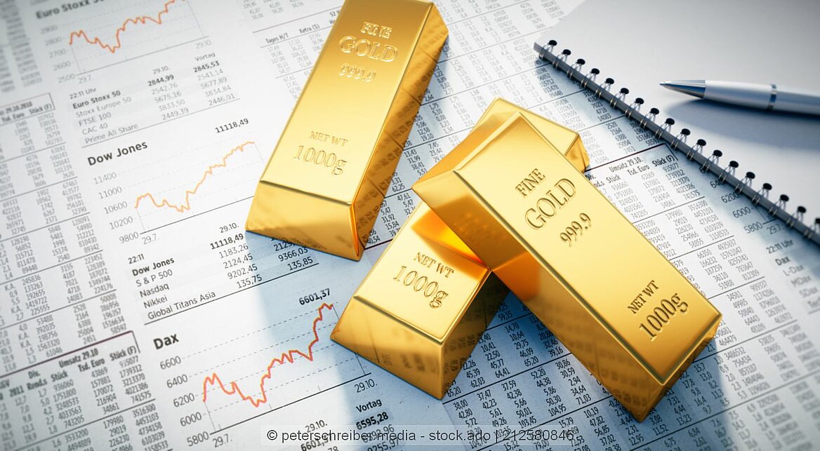 Drei Goldbarren liegen auf einer Zeitung mit Börsennachrichten.