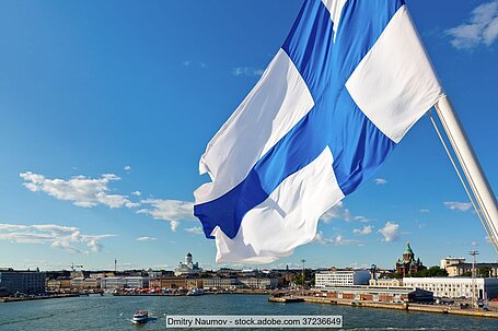 Finnische Flagge vor Hafenpanorama von Helsinki