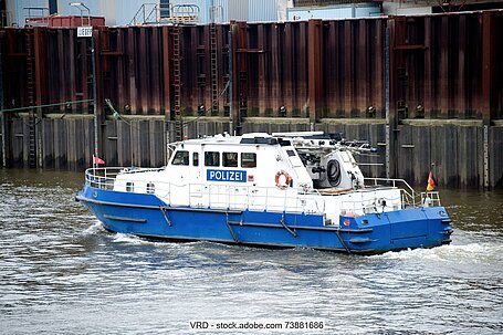 Polizeiboot im Wasser vor Hafenanlagen