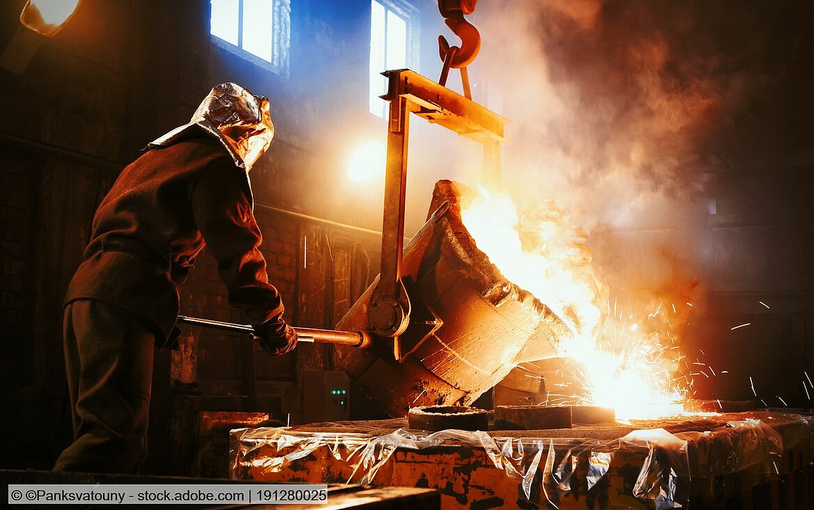 Arbeiter arbeitet im Hüttenwerk und gießt flüssiges Metall in Formen