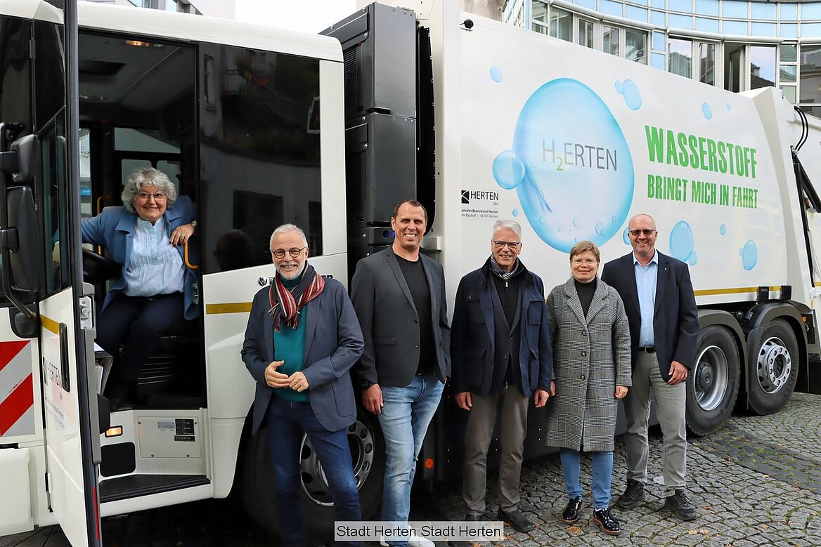 Menschen stehen vor neuen Wasserstofffahrzeug der Stadt Herten