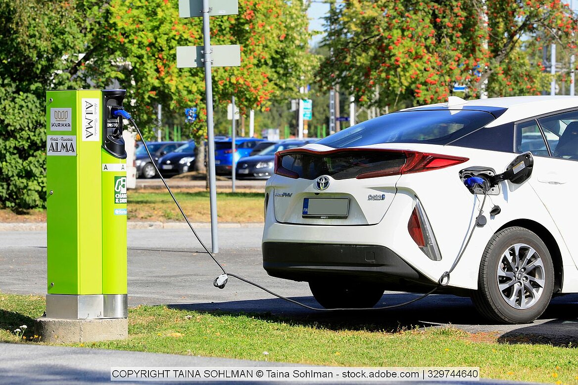 Toyota Elektroauto wird an grüner station geladen.