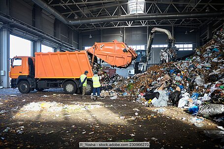 Müllfahrzeug entlädt Abfall an Entsorgungsanlage