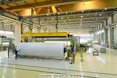 Papierrolle und weitere Maschinenteile in Industriehalle