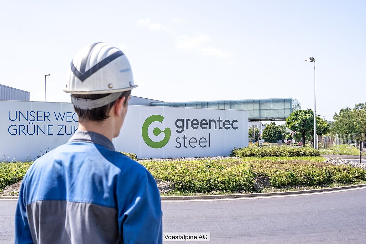 Voestalpine-Arbeiter vor dem Schriftzug Greentec Steel