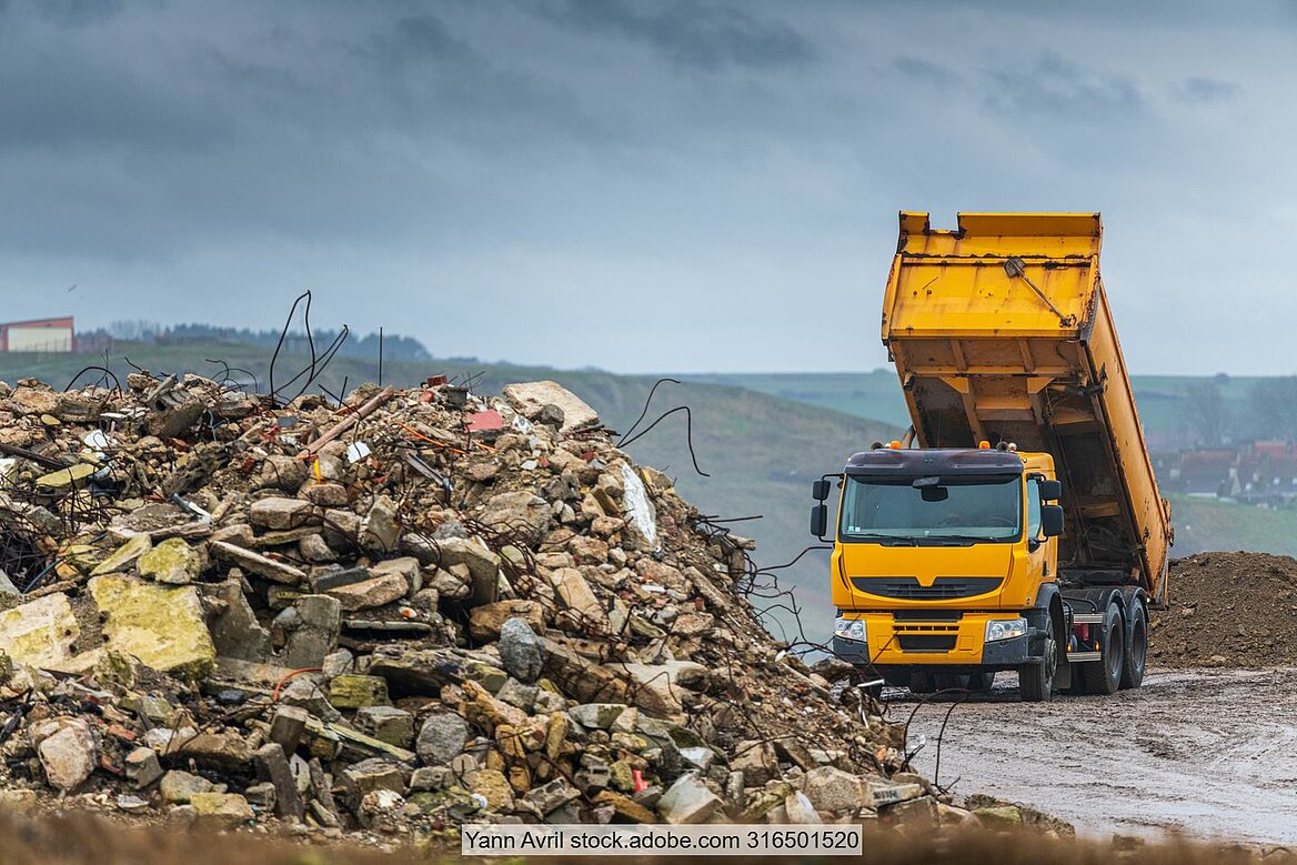 Lastwagen entlädt Abfall auf Deponie