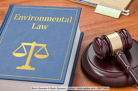 Ein Gesetzbuch für Umweltrecht liegt neben einem Richterhammer.
