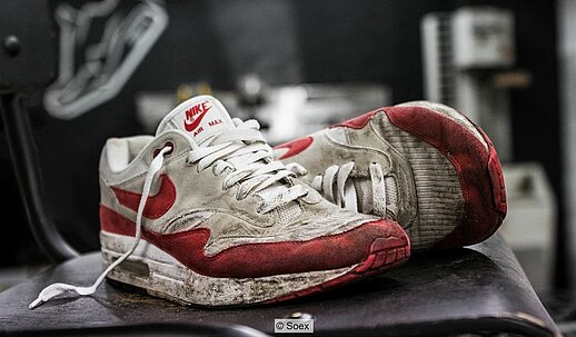 Alter, dreckiger Nike-Turnschuh in rot und weiß