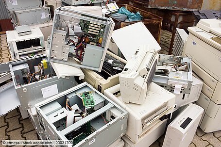 Entsorgte Computer, Drucker und Faxgeräte auf gepflasterter Fläche