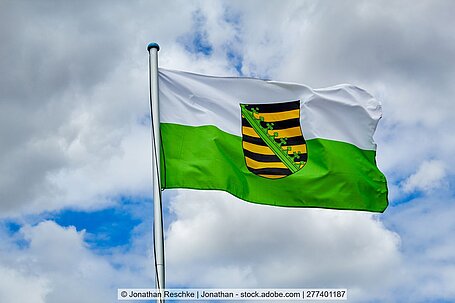 Wehende grün-weiße Flagge des Freistaats Sachsen.