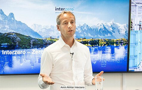 Axel Schweitzer vor Bildschirm mit Aufrschrift "Interzero""