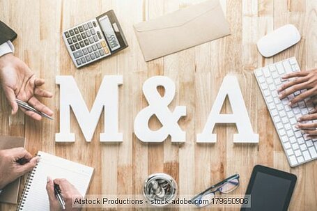 M & A auf einem Tisch mit Tastatur und Taschenrechner