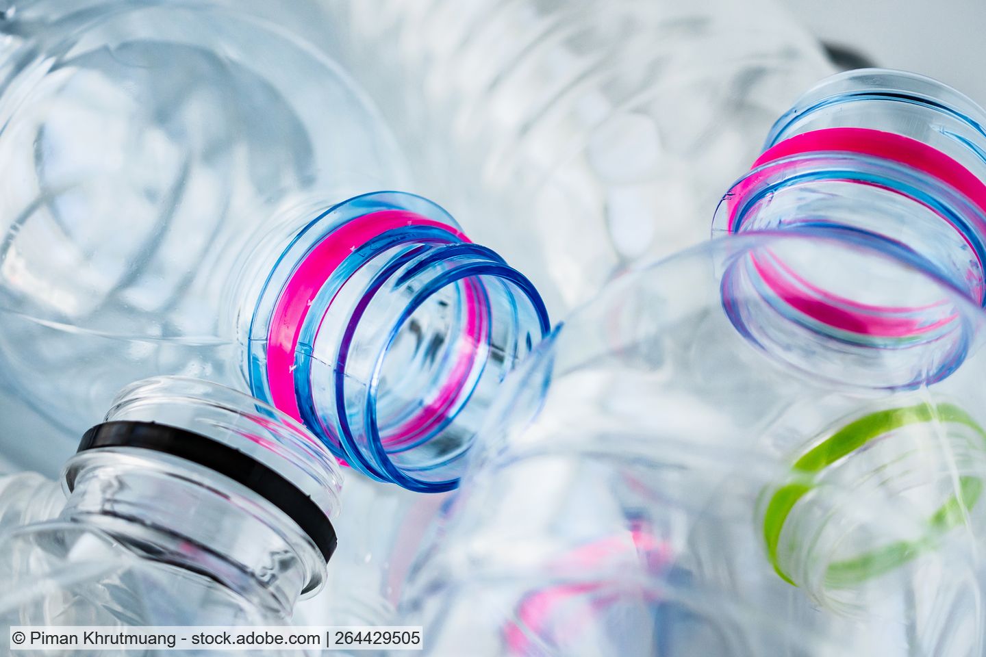 Mehrere klare PET-Flaschen mit Verschlussringen in unterschiedlichen Farben