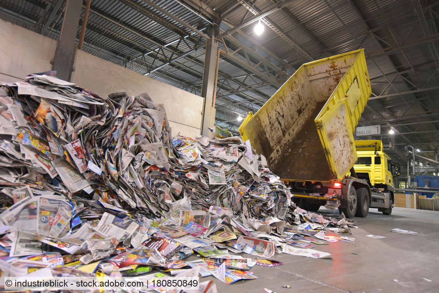 LKW schüttet Ladung alter Zeitungen in Lagerhalle ab