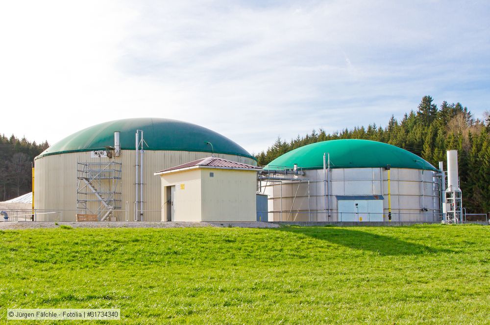 Eine Biogasanlage auf einer Wiese.