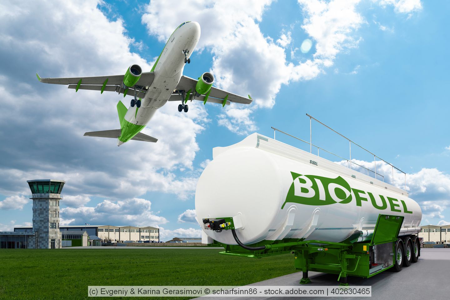 Ein Tank mit Bio-Fuels steht auf einem Flughafengelände und darüber fliegt ein Flugzeug.