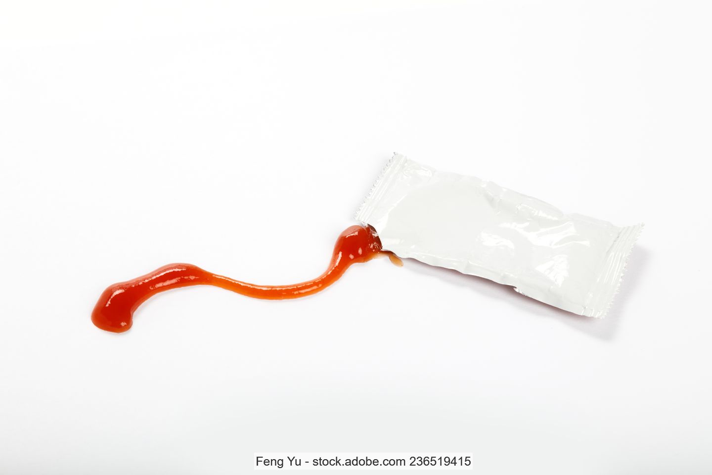 Einzelportion Ketchup in einer geöffneten Sachet-Verpackung