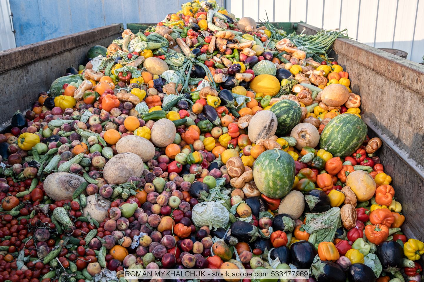 Verschiedene Obst- und Gemüsesorten auf Haufen in großem Container
