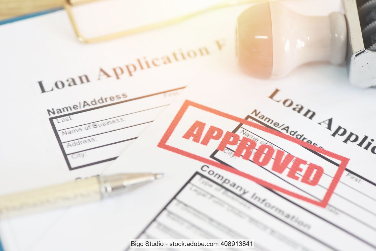 Antragsunterlagen für Kredit auf englisch mit rotem Stempelaufdruck "Approved"