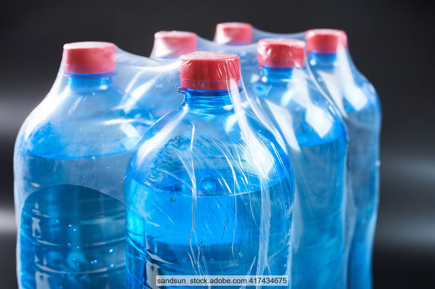 Mit Wasser gefüllte Einwegflaschen aus PET, mit Schrumpffolie zu einem Sechserpack verpackt.in 