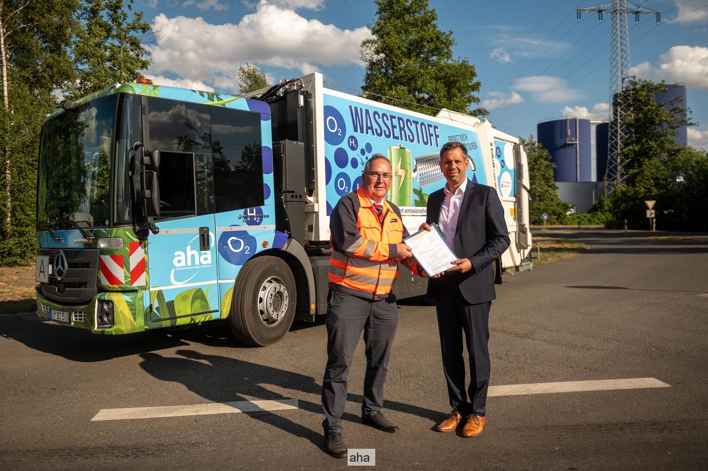 Thomas Schwarz (Geschäftsführer aha) und Umweltminister Olaf Lies vor einem Wasserstoff-Abfallsammelfahrzeug