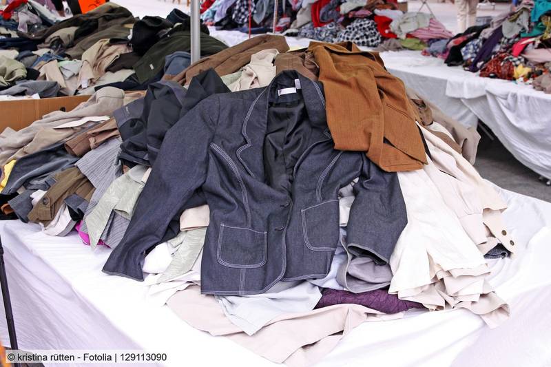 Foto von einem Stapel verschiedener gebrauchter Kleidungsstücke auf einem Tisch